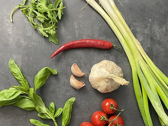 Čerstvé suroviny - rukola, bazalka, česnek, chilli, jarní cibulka a rajčata