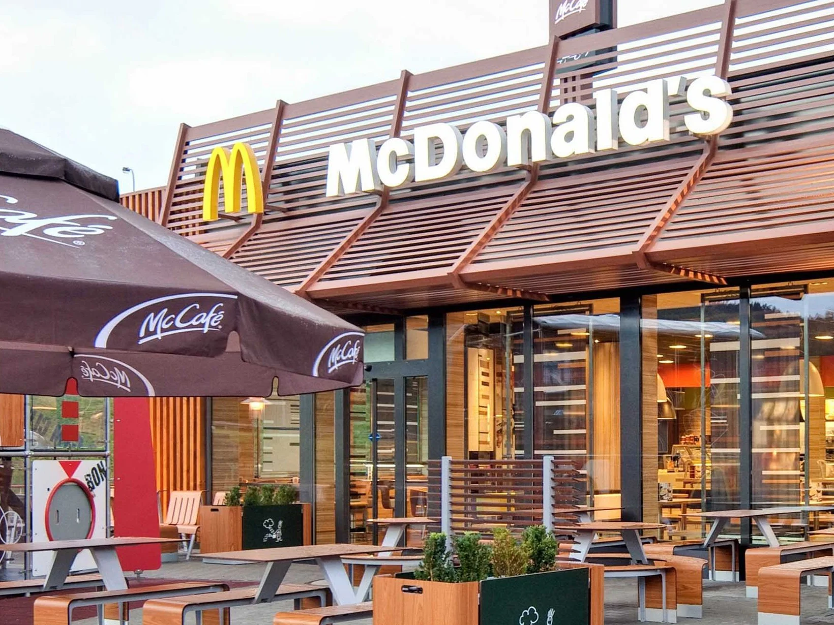 Samostatně stojící restaurace McDonald's s venkovní terasou a dětským hřištěm