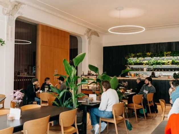 Olomouc, Sokolská - kavárna s posezením u velkého stolu a barem v zadní části