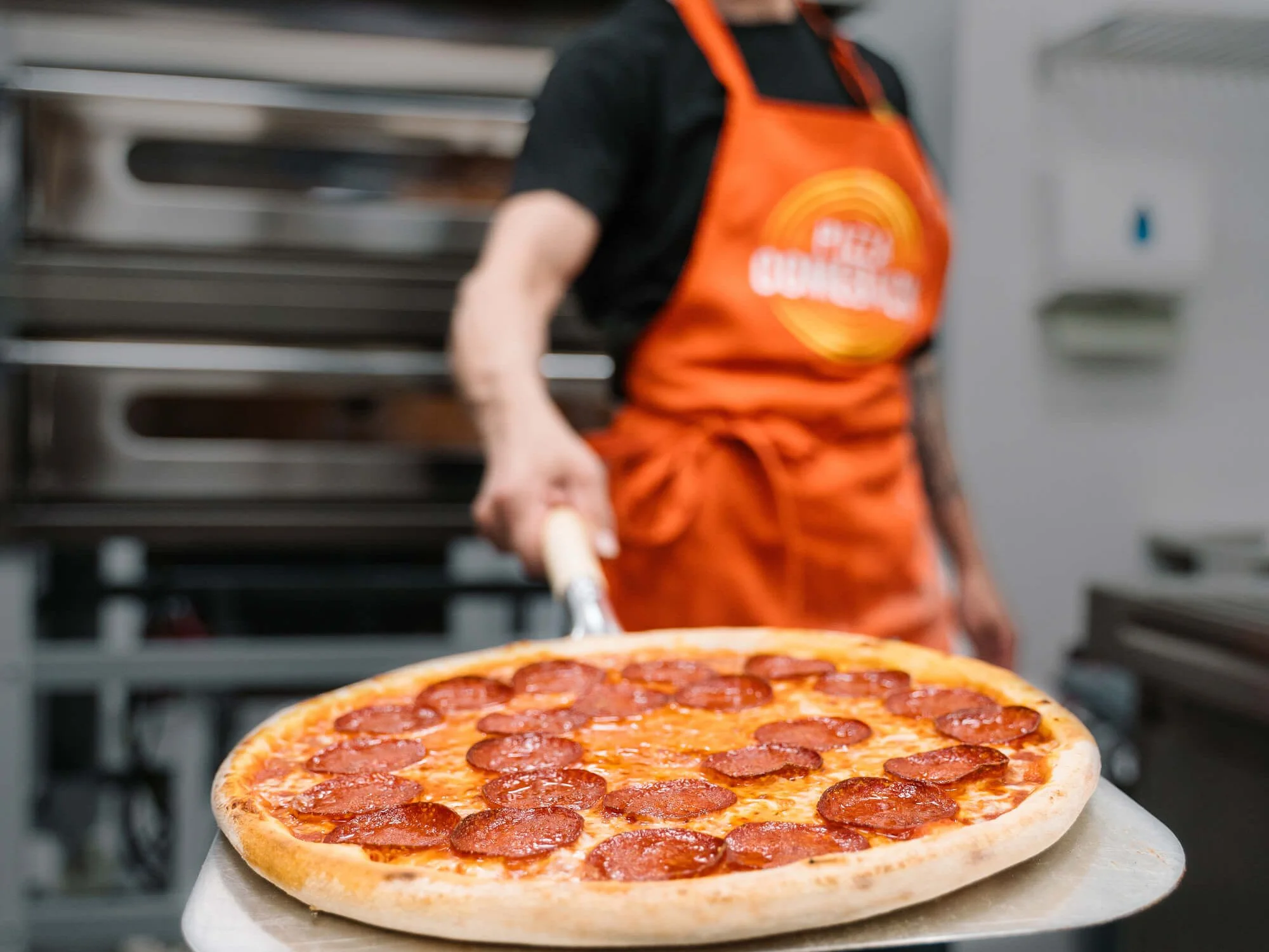 Pepperoni pizza na lopatě v kuchyni pobočky