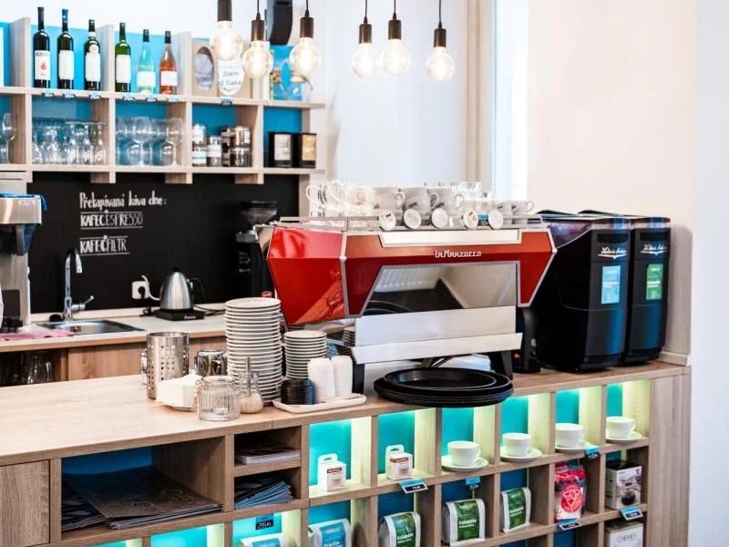 Bar s espresso strojem a regály s kávou v pobočce Kafec