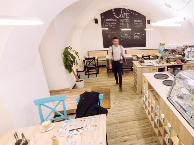 Klenutý prostor kavárny Kafec s barem a tabulí s nabídkou